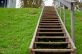 Slope of a hill with wooden ascending stairs Royalty Free Stock Photo
