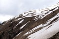 Slope of the mountain covered in places with snow cloudy day, Caucasus in spring Royalty Free Stock Photo