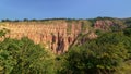 Slope with pink rock cliffs and green trees of Rapa Rosie , the grand canyon of Romania, under a clear blue sky Royalty Free Stock Photo