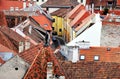 Sloped brown clay tile roofs in old european town in aerial view. white brick chimneys