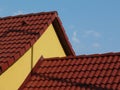 clay tile roof detail. yellow stucco exterior. blue sky and white cloud Royalty Free Stock Photo