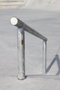 Sloped metal rail for grind tricks in an empty concrete skatepark