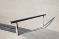 Sloped metal rail for grind tricks in an empty concrete skatepark