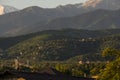 The slopes of the mountains of the Trans-Ili Alatau during the summer sunrise, on which houses stand in the distance.