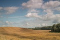 Sloping montainous field in the country side with white beautiful clouds Royalty Free Stock Photo