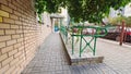 A sloping ramp made of tile with metal railings was made for wheelchair users to enter the brick building. Thus, a barrier-free en Royalty Free Stock Photo