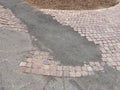 Sloppy brick sidewalk repair. Brick walkway patched with asphalt after construction project Royalty Free Stock Photo