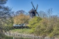 Slottsmollan Castle wind mill in Malmo Kungsparken among blooming trees as a park `s canal flows underneath the wooden windmill