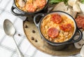 Slovak Christmas national cabbage soup in small black pot with sausage on the tablecloth background Royalty Free Stock Photo