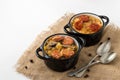 Slovak Christmas national cabbage soup in two small black pots with sausage on the jute background Royalty Free Stock Photo