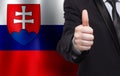 Slovak concept. Businessman showing thumb up on the background of flag of Slovakia