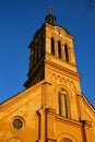 Slovak evangelical Augsburg church in Modra in evening spring sunshine, clear blue skies, front facade with tower clock visible.