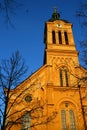 Slovak evangelical Augsburg church in Modra in evening spring sunshine, clear blue skies, front facade with tower clock visible.