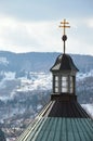 Slovak twin cross placed on baroque building of central church of calvary in Banska Stiavnica, Slovakia, snow covered hills i