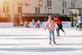 Slovakia.Bratislava.28.12.2018 .Group of teenage friends ice skating on an ice rink.Soft,Selective focus.People ice