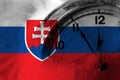 Slovensko, slovenská vlajka s hodinami blízko polnoci v pozadí. Šťastný nový rok koncept
