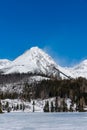 Slovensko, Štrbské Pleso: Pohľad na zamrznuté jazero vo Veľkých Tatrách. Hory v pozadí, stromy a jazero v popredí. Wi