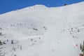 Ski Lift, Skiers and Snow Guns on a Wide Ski Slope Royalty Free Stock Photo