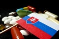 Slovakian flag with lot of medical pills isolated on black background