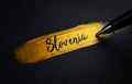 Slovenia Handwriting Text on Golden Paint Brush Stroke