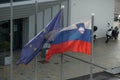 Slovenian and European Union flags waving on the flagpoles.