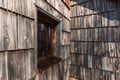 Slovenian mountain cottage window and worn wooden tiled facade