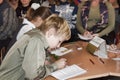 An unknown junior student at a desk writes something in a notebook at a lesson in one of the schools in Sloviansk