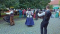 Folklore dancers performing on street with accordeon player