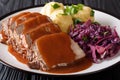 Slow Cooker Pot Roast Sauerbraten with spicy sauce, potato dumplings and red cabbage close-up. horizontal