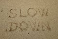 Slow down, mindfulness concept written on sand Royalty Free Stock Photo