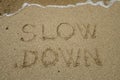 Slow down, mindfulness concept written on sand Royalty Free Stock Photo