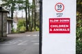 Slow down road safety caution children and animals at zoo entrance