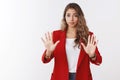 Slow down take easy. Girl restraining giving negative reply raising extended palms refusal, stop gesture asking control Royalty Free Stock Photo