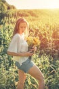 Slow Living concept New Lifestyle Trend. Relaxing young woman with lowers in nature, in corn, sunflower field