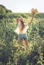 Slow Living concept New Lifestyle Trend. Relaxing young woman with lowers in nature, in corn, sunflower field