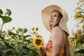 Slow Living concept New Lifestyle Trend. Relaxing young woman with lowers in nature, in corn, sunflower field