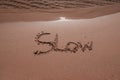 slow mindfulness concept written on sand Royalty Free Stock Photo