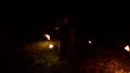 Slow-mo of man in dark rotates burning torch. Low key. Fire show. Close-up.