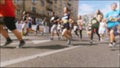 Slow motion blurred footage of marathoners running on street