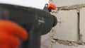 SLOW MOTION,: Builder working uses an electric drill to mount a wall panel. Man drills hole using perforator. Male hands Royalty Free Stock Photo