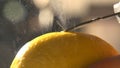 Slow motion citrus zester on lemon skin, twirls of zest falling against. macro