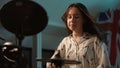 Slow motion. Close-up. A young talented girl musician is diligently playing a composition on an electronic drum kit