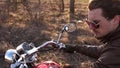 Slow motion of cool young biker, on red chopper, expressive looking back