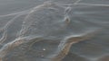 Slow motion handheld closeup of small waves on a beach with caustics