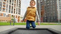 Slow motion of happy child enjoying jumping on trampoline at playground. Active child, sports and development, kids playing Royalty Free Stock Photo