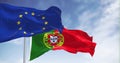 Slow motion loop of Flags of Portugal waving with EU flag on a clear day