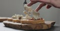 Slow motion man add ricotta to slice of ciabatta with fig marmalade and pancetta Royalty Free Stock Photo