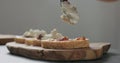 Slow motion man add ricotta to slice of ciabatta with fig marmalade and pancetta Royalty Free Stock Photo