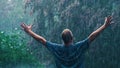 Catharsis: A man stands with his arms spread apart triumphantly in a rain storm