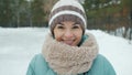 Slow motion portrait of attractive young lady in winter clothes standing ourdoors in park in winter